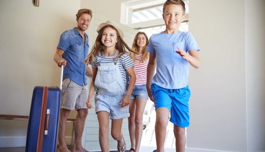 Family Arriving At Summer Vacation Rental
