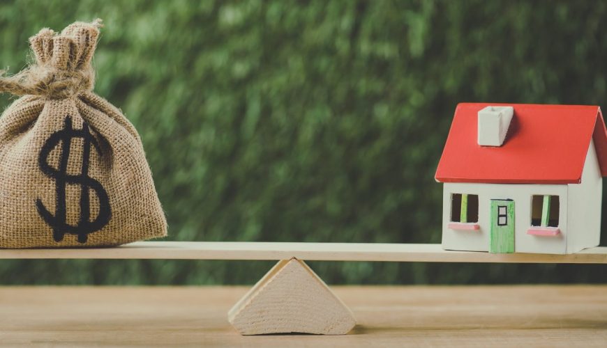 money bag with dollar symbol and house model balancing on swing on green background