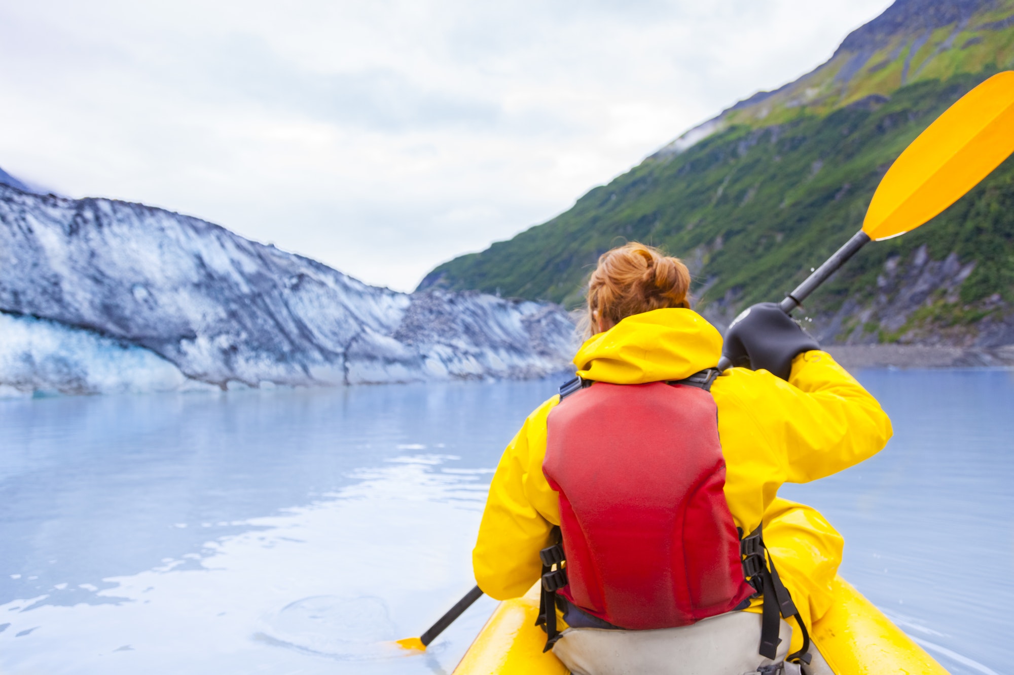 USA, Alaska, Valdez, young woman in kayak in front of Valdez Glacier